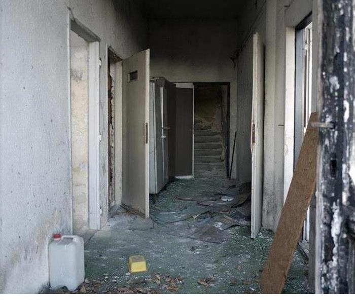 A hallway with extreme fire damage after a dryer fire destroyed a home