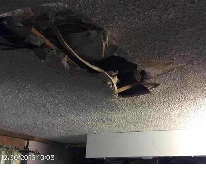 A water damaged ceiling hangs precariously over a clients living room.